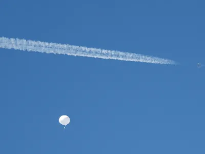 FILE PHOTO: A jet flies by a suspected Chinese spy balloon as it floats off the coast in Surfside Beach, South Carolina, U.S. February 4, 2023. REUTERS/Randall Hill/File Photo