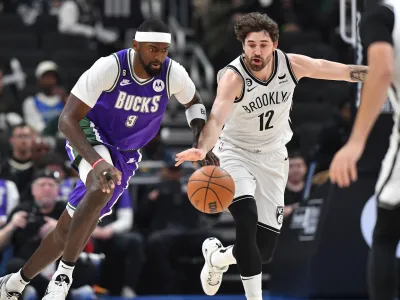 Mar 9, 2023; Milwaukee, Wisconsin, USA; Milwaukee Bucks forward Bobby Portis (9) and Brooklyn Nets forward Joe Harris (12) battle for the ball at Fiserv Forum. Mandatory Credit: Michael McLoone-USA TODAY Sports