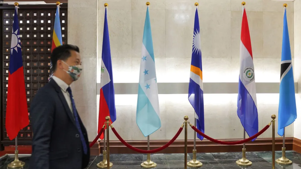A man walks in front of flags of Honduras, Taiwan, and other countries, displayed at the Ministry of Foreign Affairs building, in Taipei, Taiwan March 23, 2023. REUTERS/Annabelle Chih