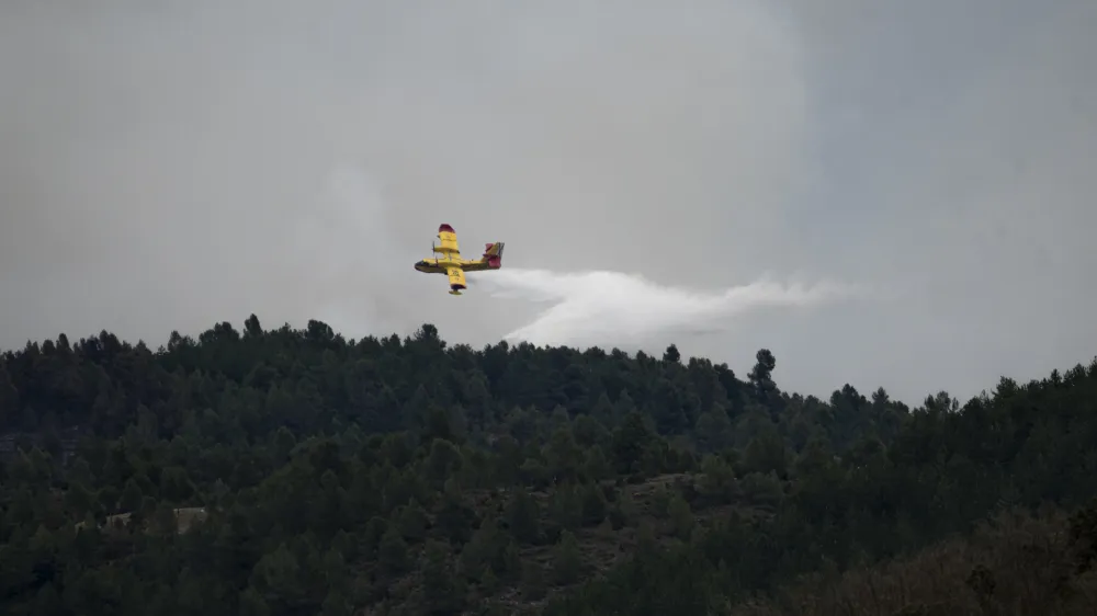 24 March 2023, Spain, San Agustin: A helicopter flies over San Agustin to help in extinguishing the forest fire. The forest fire advanced without control after burning 800 hectares and forcing the evacuation of eight municipalities and districts. Photo: Lorena Sopêna/EUROPA PRESS/dpa