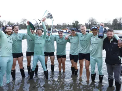 Rowing - University Boat Race - Oxford v Cambridge - River Thames, London, Britain - March 26, 2023 Cambridge coxswain Jasper Parish celebrates with the trophy and teammates after winning the men's race Action Images via Reuters/Andrew Boyers