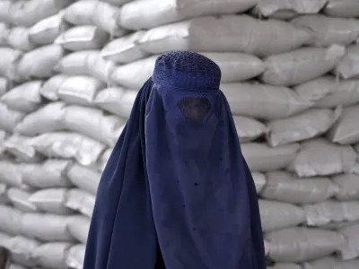 FILE - An Afghan woman waits to receive a food ration distributed by a South Korean humanitarian aid group, in Kabul, Afghanistan, May 10, 2022. (AP Photo/Ebrahim Noroozi, File)