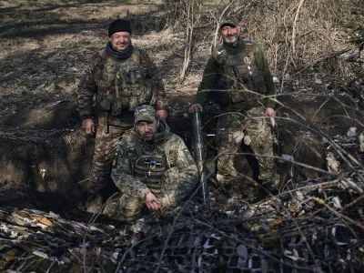 Ukrainian soldiers of the 28th brigade gather in a trench near Russian positions close to Bakhmut, Donetsk region, Ukraine, Monday, March 27, 2023. (AP Photo/Libkos)