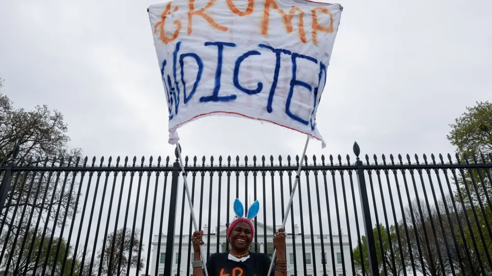 Nadine Seiler holds a "Trump Indicted" sign in front of the White House after former U.S. President Donald Trump's indictment by a Manhattan grand jury following a probe into hush money paid to porn star Stormy Daniels, in Washington, U.S. March 31, 2023. REUTERS/Jonathan Ernst
