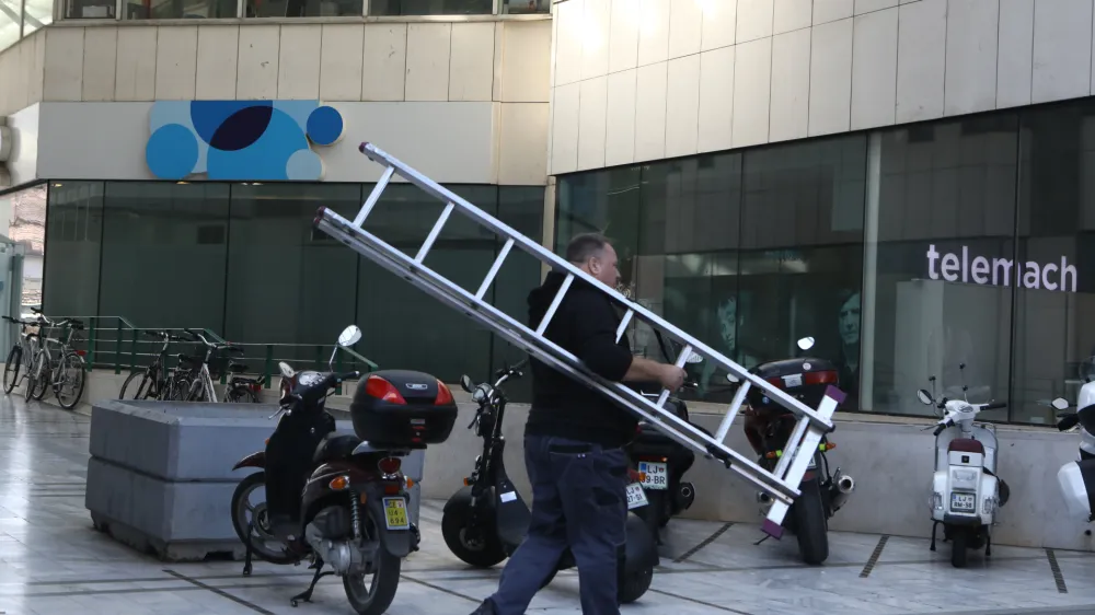  mobilni operater Telemach in Telekom – delavec, lestev, telefoniranje <br><br>- 23.09.2022 - ploščad Trg Ajdovščina pri Metalki v Ljubljani <br> <br>//FOTO: Luka Cjuha