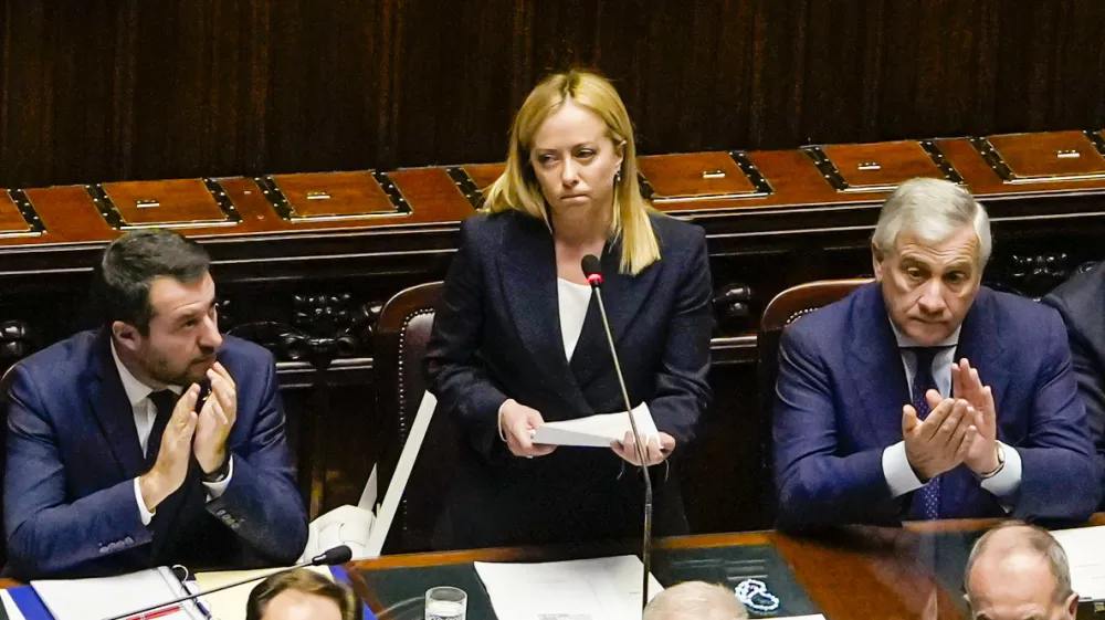 Italian Premier Giorgia Meloni, center, addresses the lower Chamber ahead of a confidence vote for her Cabinet, Tuesday, Oct. 25, 2022. Giorgia Meloni, whose party with neo-fascist roots finished first in recent elections, is Italy's first far-right premier since the end of World War II. She is also the first woman to serve as Italian premier. At left is Infrastructures Minister Matteo Salvini, and at right, Foreign Minister Antonio Tajani. (AP Photo/Alessandra Tarantino)