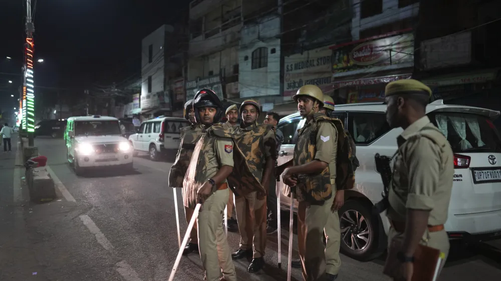 Policemen stand guard the area where gangster-turned-politician Atiq Ahmad and his brother Ashraf were shot, in, Prayagraj, India, Saturday, April 15, 2023. (AP Photo/Rajesh Kumar Singh)