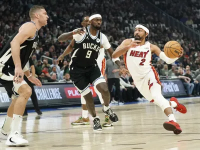 Miami Heat's Gabe Vincent (2) drives to the basket against Milwaukee Bucks' Bobby Portis (9) and Brook Lopez during the first half of Game 2 of an NBA basketball first-round playoff series Wednesday, April 19, 2023, in Milwaukee. (AP Photo/Aaron Gash)