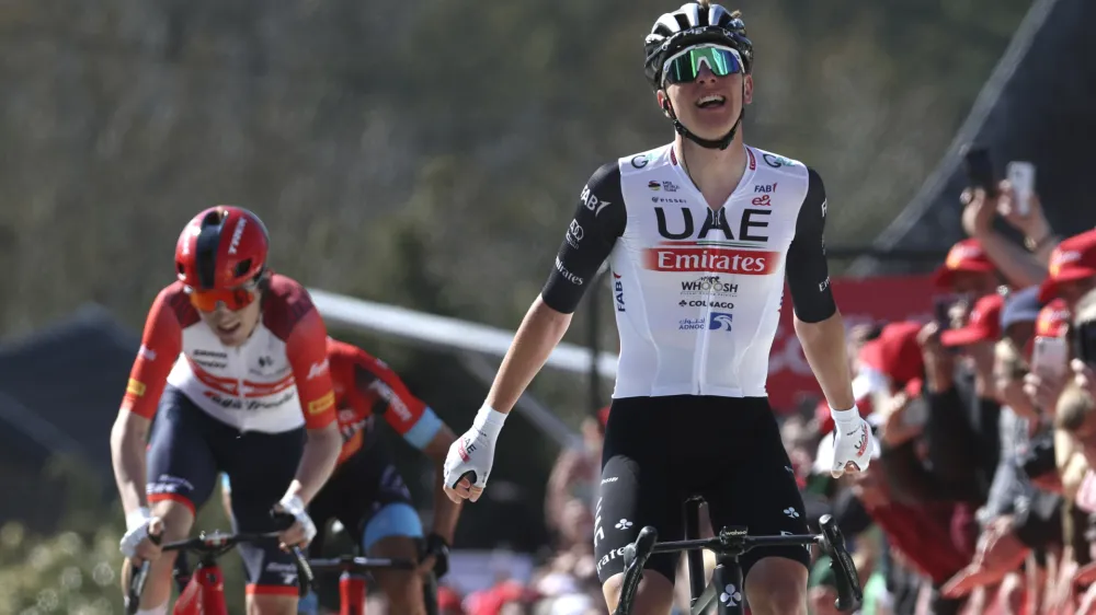 Slovenia's Tadej Pogacar of the UAE Team Emirates, right, crosses the finish line to win the Belgian cycling classic and UCI World Tour race Fleche Wallonne (Walloon Arrow), in Huy, Belgium, Wednesday, April 19, 2023. (AP Photo/Geert Vanden Wijngaert)