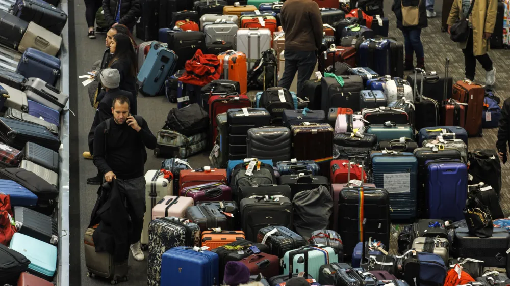 Luggage is amassed in the baggage claim area at Toronto Pearson International Airport, as a major winter storm disrupts flights in and out of the airport, in Toronto, Saturday, Dec. 24, 2022. (Cole Burston /The Canadian Press via AP)