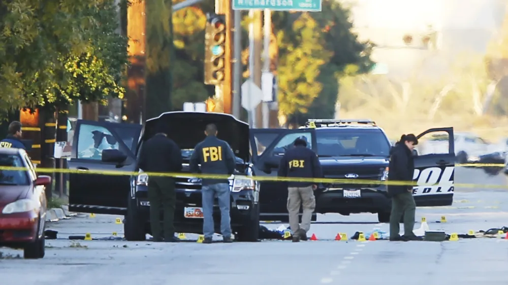 FBI and police investigator are seen around a vehicle in which two suspects were shot following a mass shooting in San Bernardino, California December 3, 2015. Authorities on Thursday were working to determine why Syed Rizwan Farook, 28, and Tashfeen Malik, 27, who had a 6-month-old daughter together, opened fire at a holiday party of his co-workers in Southern California, killing 14 people and wounding 17 in an attack that appeared to have been planned.  REUTERS/Mike Blake