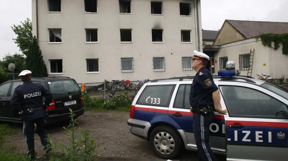 Austrian police stand in front of an asylum seekers home after a fire in Klagenfurt June 12, 2008. The reason of the blaze is unknown, but at least 12 persons were injured, local authorities said.  REUTERS/Fabrizio Bensch (AUSTRIA)