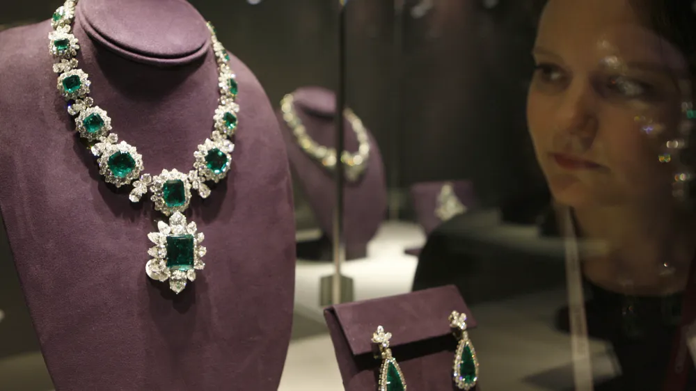 An employee looks at 'The Bvlgari Emerald Suite' on display during a press preview at Christie's London, Friday, Sept. 23, 2011. The suite includes a necklace estimated to reach 975,000 British pounds US $1.5 million, a pendant 450,000 British pounds US $ 700,000, a ring 520,000 British pounds US $800,000, a bracelet 325,000 British pounds US $500,000 and earrings 130,000 British pounds US $200,000. They go on sale as part of the Collection of Elizabeth Taylor at Christie's New York in December. (AP Photo/Akira Suemori)