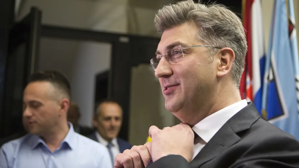 Croatia's Prime Minister, Andrej Plenkovic, adjusts his tie before addressing the media at his party headquarters in Zagreb, Croatia, Thursday, April 27, 2017. Plenkovic has moved to replace three ministers from a junior party in the government, triggering a crisis in the ruling conservative coalition. (AP Photo/Darko Bandic)
