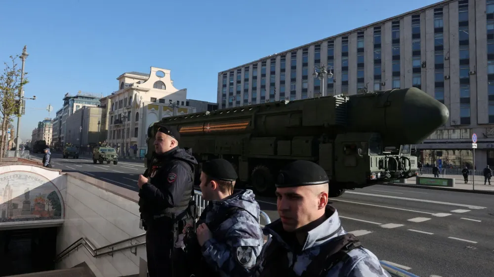 Law enforcement officers stand guard as Russian Yars intercontinental ballistic missile systems and other armoured vehicles drive along a street before a military parade on Victory Day, which marks the 78th anniversary of the victory over Nazi Germany in World War Two, in Moscow, Russia May 9, 2023. REUTERS/Yulia Morozova