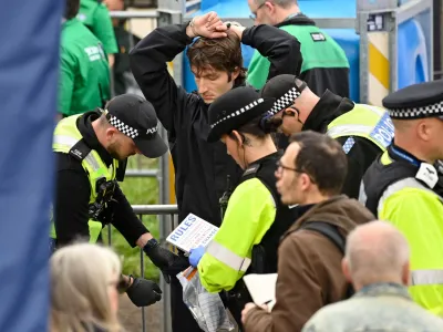 Protesters from climate protest group 'Just Stop Oil' are apprehended by police officers in the crowd close to where Britain's King Charles III and Britain's Camilla, Queen Consort will be crowned at Westminster Abbey in central London on May 6, 2023. - The set-piece coronation is the first in Britain in 70 years, and only the second in history to be televised. Charles will be the 40th reigning monarch to be crowned at the central London church since King William I in 1066.   JUSTIN TALLIS/Pool via REUTERS