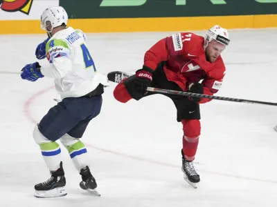Tanner Richard of Switzerland, right, fights for a puck with Aleksandar Magovac of Slovenia during the group B match between Switzerland and Slovenia at the ice hockey world championship in Riga, Latvia, Saturday, May 13, 2023. (AP Photo/Roman Koksarov)