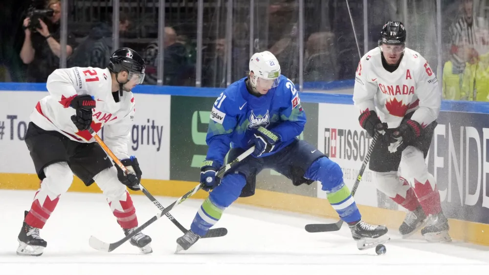 Jan Drozg (v modrem dresu) je Kanadi zabil dva zadetka in je bil ob vratarju Luki Gračnarju najbolj&scaron;i slovenski hokejist.