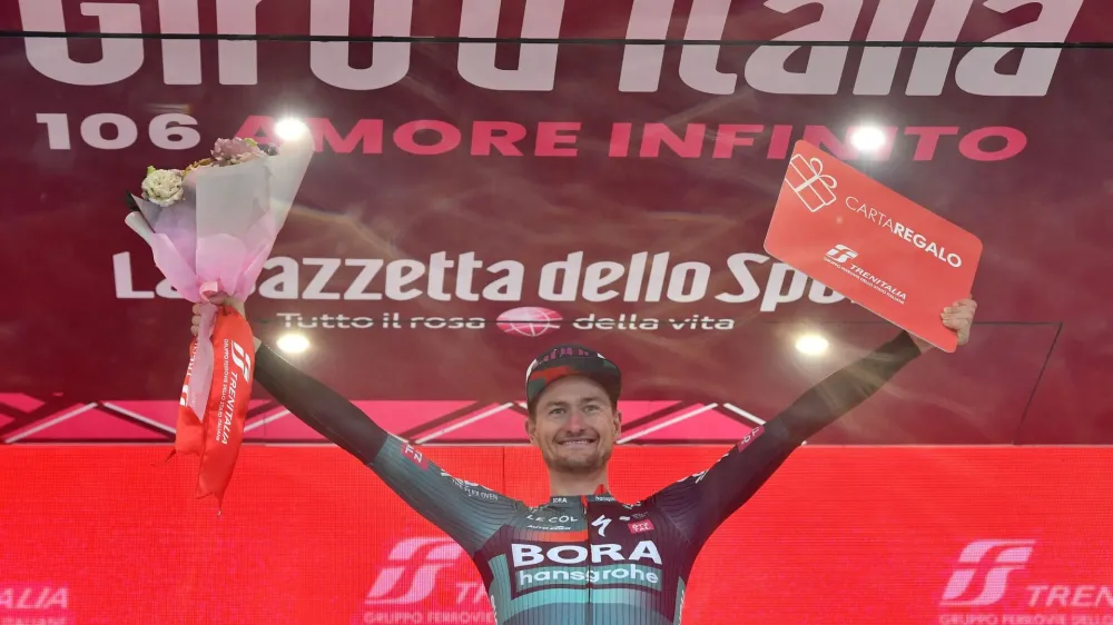 Cycling - Giro d'Italia - Stage 14 - Sierre to Cassano Magnago - Italy - May 20, 2023 BORA – hansgrohe's Nico Denz celebrates on the podium after winning stage 14 REUTERS/Jennifer Lorenzini