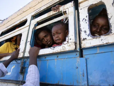 Refugees who fled the conflict in Ethiopia's Tigray region ride a bus going to the Village 8 temporary shelter, near the Sudan-Ethiopia border, in Hamdayet, eastern Sudan, on Dec. 1, 2020. (AP Photo/Nariman El-Mofty)
