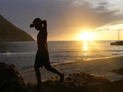 A youth walks on the seaside during sunset in Chuao, Aragua state, Venezuela, Tuesday, June 6, 2023. (AP Photo/Matias Delacroix)