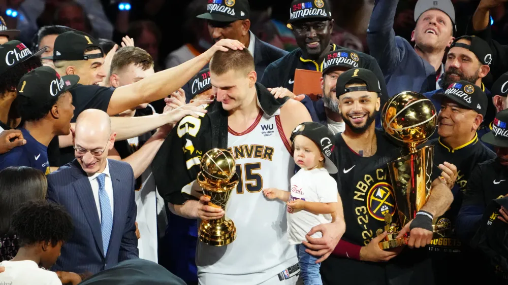 Jun 12, 2023; Denver, Colorado, USA; Denver Nuggets center Nikola Jokic (15) holds his daughter as he celebrates winning the Bill Russell NBA Finals MVP Award after the Nuggets won the 2023 NBA Championship against the Miami Heat at Ball Arena. Mandatory Credit: Ron Chenoy-USA TODAY Sports