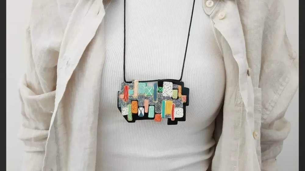 Ogrlica na fotografiji izhaja iz grafike Lojzeta Spacala Ribi&scaron;ko naselje, 1964. F Osebni arhiv