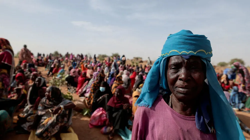 FILE PHOTO: Halime Adam Moussa, a Sudanese refugee who is seeking refuge in Chad for a second time, waits with other refugees to receive a food portion from World Food Programme (WFP), near the border between Sudan and Chad in Koufroun, Chad, May 9, 2023. REUTERS/Zohra Bensemra/File Photo
