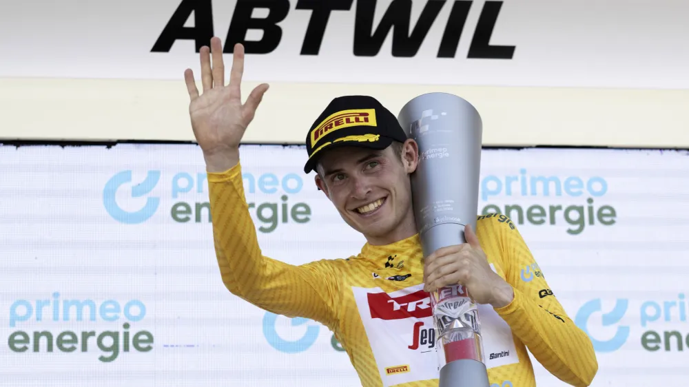 Denmark's Mattias Skjelmose holds the trophy as he celebrates on the podium after winning the Tour de Suisse, during the eighth and final stage, a 25,7 km individual time trial, from St. Gallen to Abtwil, at the 86th Tour de Suisse cycling race, in Abtwil, Sunday, June 18, 2023. (Gian Ehrenzeller/Keystone via AP)