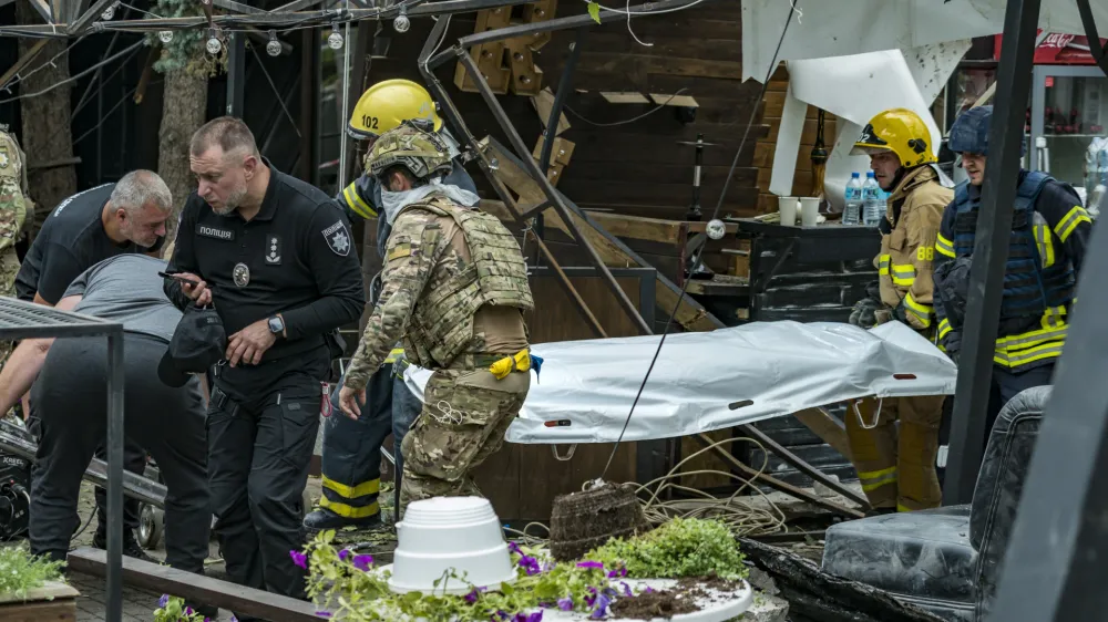 28 June 2023, Ukraine, Kramatorsk: Members of a rescue unit carry a victim killed when a Russian missile hit the center of the city of Kramatorsk. At least eleven people were killed in the Russian missile attack on a popular pub in the eastern Ukrainian city of Kramatorsk. Photo: Celestino Arce Lavin/ZUMA Press Wire/dpa