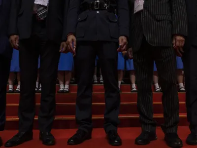 Disciplined Services officials pose with students during a ceremony to mark the 26th anniversary of Hong Kong's return to Chinese rule  in Hong Kong, Saturday, July 1, 2023. (AP Photo/Louise Delmotte)
