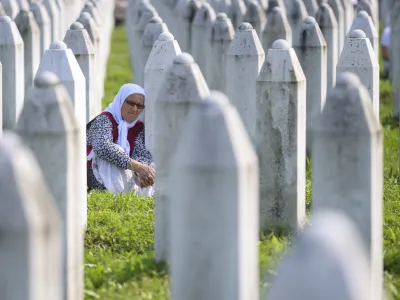 A Bosnian muslim woman mourns next to the grave of her relative, victim of the Srebrenica genocide, in Memorial Centre in Potocari, Bosnia, Tuesday, July 11, 2023. Thousands gather in the eastern Bosnian town of Srebrenica to commemorate the 28th anniversary on Monday of Europe's only acknowledged genocide since World War II. (AP Photo/Armin Durgut)