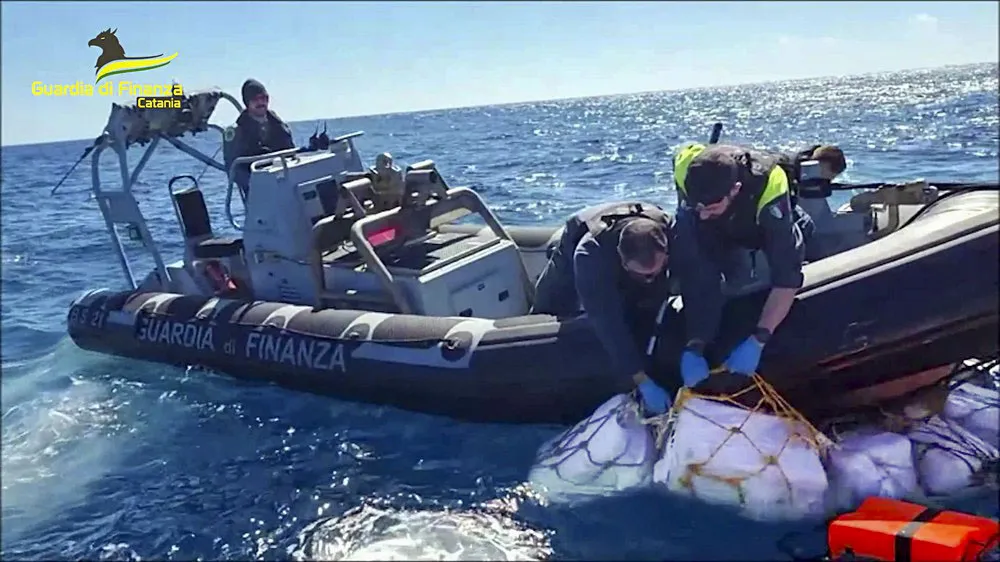 Boxes containing cocaine are taken on board in the Sicilian Strait off Catania in this picture made available by the Italian Financial Police on Monday, April 17, 2023. Some two thousand kilograms of cocaine, left afloat in open waters with a tracking device attached, were sized by the Italian Financial Police on Monday. (Italian Financial Police via AP)