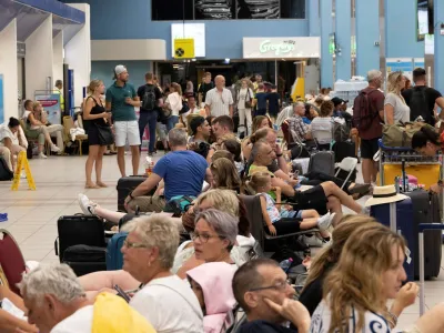 Tourists wait for departing planes at the airport, after being evacuated following a wildfire on the island of Rhodes, Greece, July 24, 2023. REUTERS/Nicolas Economou