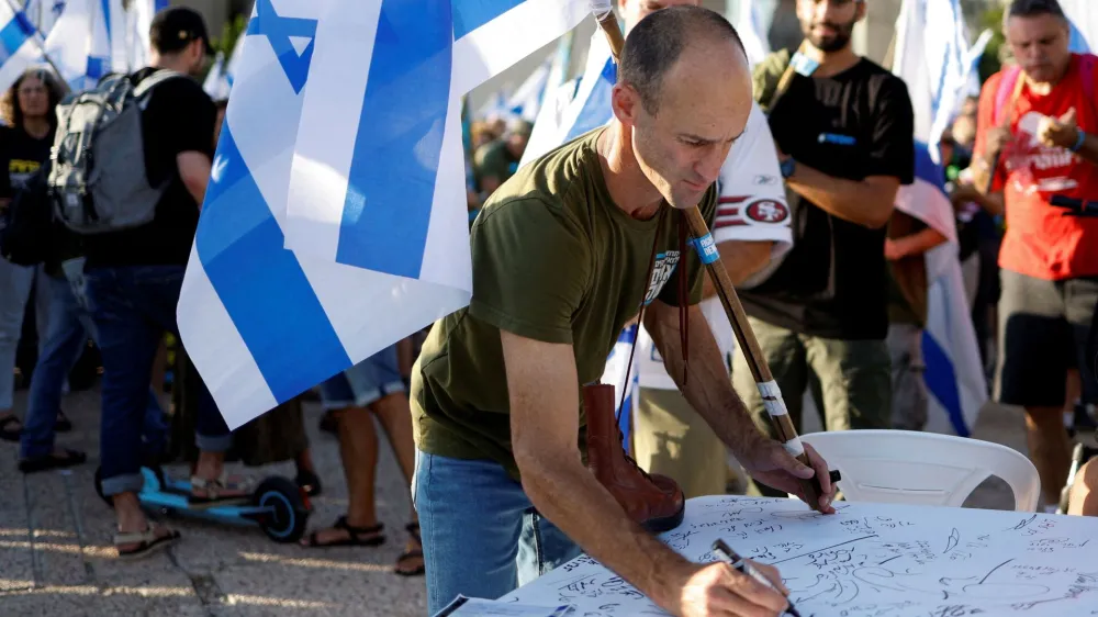 Vrsta izraelskih rezervistov napoveduje, da se ne bodo odzvali vpoklicu, če bo vladna reforma obveljala. O tem so v Tel Avivu podpisovali peticijo. Foto: Reuters