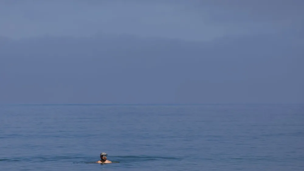 A swimmer keeps cool in the ocean in La Jolla, California, U.S., July 26, 2023. REUTERS/Mike Blake