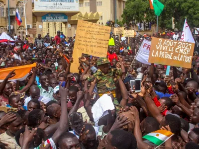 Men a hold a child dressed in military uniform as they gather with thousands of anti-sanctions protestors in support of the putschist soldiers in the capital Niamey, Niger August 3, 2023. REUTERS/Mahamadou Hamidou NO RESALES. NO ARCHIVES