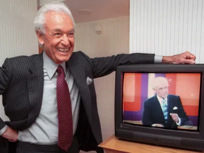 FILE - Legendary game show host Bob Barker, 73, leans on his hotel room television showing his image, during an interview Monday, Oct. 23, 2000 in Cambridge, Mass. (AP Photo/Michael Dwyer, File)