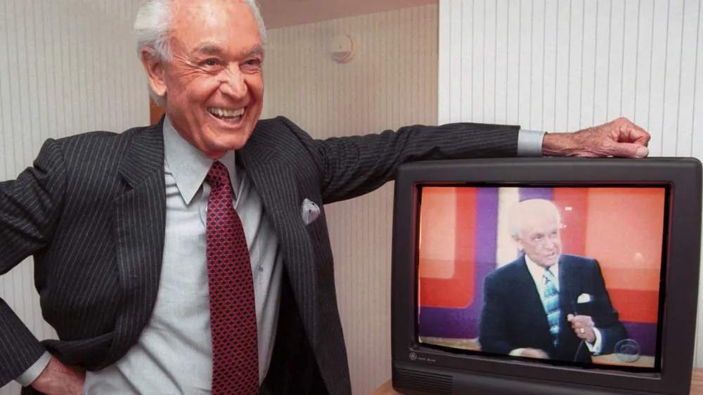 FILE - Legendary game show host Bob Barker, 73, leans on his hotel room television showing his image, during an interview Monday, Oct. 23, 2000 in Cambridge, Mass. (AP Photo/Michael Dwyer, File)