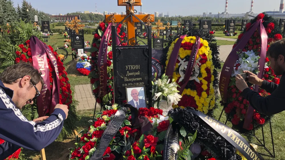 Journalists take photos of the grave of Dmitry Utkin, who oversaw Wagner Group's military operations, at the Federal Military Memorial Cemetery in Mytishchy, outside Moscow, Russia, Thursday, Aug. 31, 2023. Utkin, whose military call sign Wagner gave the name to the group, is presumed to have died in a plane crash along with Wagner's owner Yevgeny Prigozhin and other military company's officers was buried at the Federal Military Memorial Cemetery in Mytishchy, outside Moscow on Thursday. (AP Photo/Alexander Zemlianichenko)