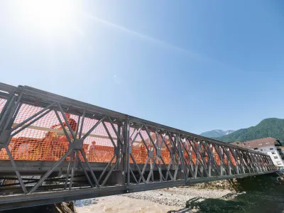 Prvi montažni mostovi že nadomeščajo tiste, ki jih je odnesla voda. Na fotografiji: montažni most čez Mežo v Mežici