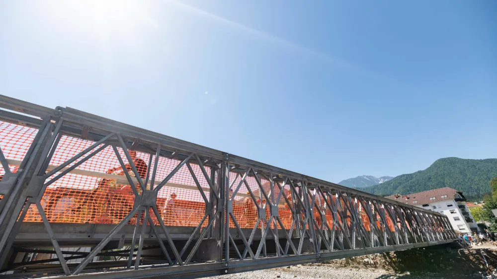 Prvi montažni mostovi že nadomeščajo tiste, ki jih je odnesla voda. Na fotografiji: montažni most čez Mežo v Mežici