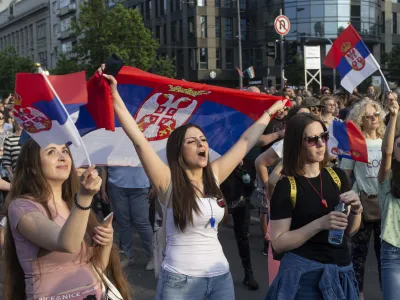 A woman shouts as she holds a Serbian flag during a protest in Belgrade, Serbia, Friday, June 9, 2023. Tens of thousands of people rallied in Serbia's capital on Friday in protest of the government's handling of a crisis after two mass shootings in the Balkan country. (AP Photo/Marko Drobnjakovic)