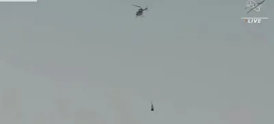 This image taken from video provided by NASA TV shows the capsule released by the Osiris-Rex spacecraft being lifted off by a helicopter after landing to Earth at Dugway Proving Ground, Utah, Sunday,Sept. 24 2023. (NASA TV via AP)