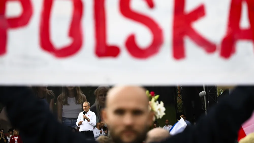 Opposition leader Donald Tusk speaks behind a poster Poland during a march to support the opposition against the governing populist Law and Justice party in Warsaw, Poland, Sunday, Oct. 1, 2023. Polish opposition leader Donald Tusk seeks to boost his election chances for the parliament elections on Oct. 15, 2023, leading the rally in the Polish capital. (AP Photo/Rafal Oleksiewicz)