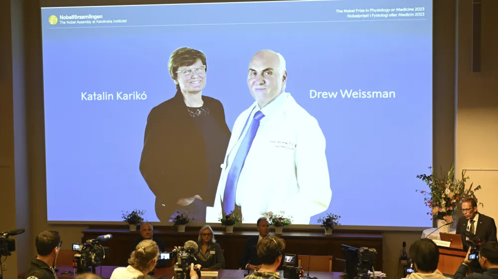 Thomas Perlmann, secretary of the Nobel Assembly, right, announces the winner of the 2023 Nobel Prize in Physiology or Medicine to Katalin Karikó and Drew Weissman, seen on screen, at the Karolinska Institute in Stockholm, Monday Oct. 2, 2023. The Nobel Prize in medicine has been awarded to Katalin Karikó and Drew Weissman for discoveries that enabled the development of effective mRNA vaccines against COVID-19.(Jessica Gow/TT News Agency via AP)