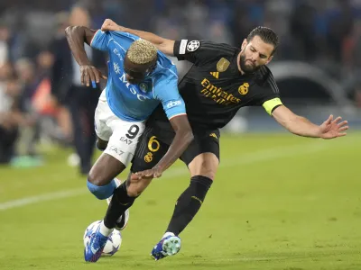 Real Madrid's Nacho, right, challenges Napoli's Victor Osimhen during the Champions League group C soccer match between Napoli and Real Madrid at the Diego Armando Maradona stadium in Naples, Italy, Tuesday, Oct. 3, 2023. (AP Photo/Alessandra Tarantino)
