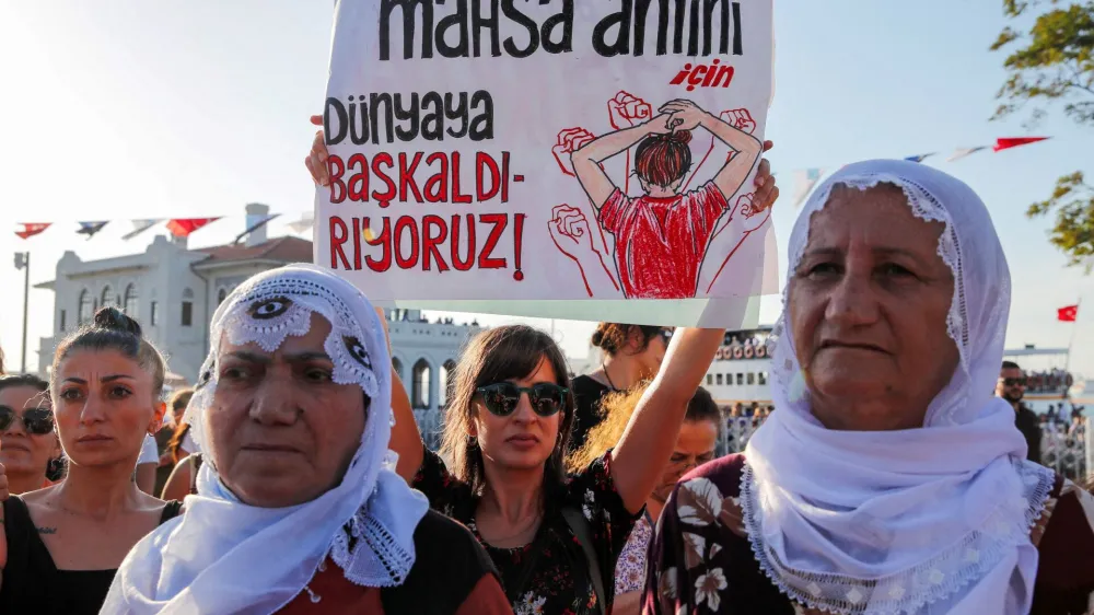FILE PHOTO: Women take part in a rally on the first anniversary of the death of Mahsa Amini which prompted protests across the country, in Istanbul, Turkey September 16, 2023. Banner reads, "We revolt against world for Mahsa Amini". REUTERS/Dilara Senkaya/File Photo