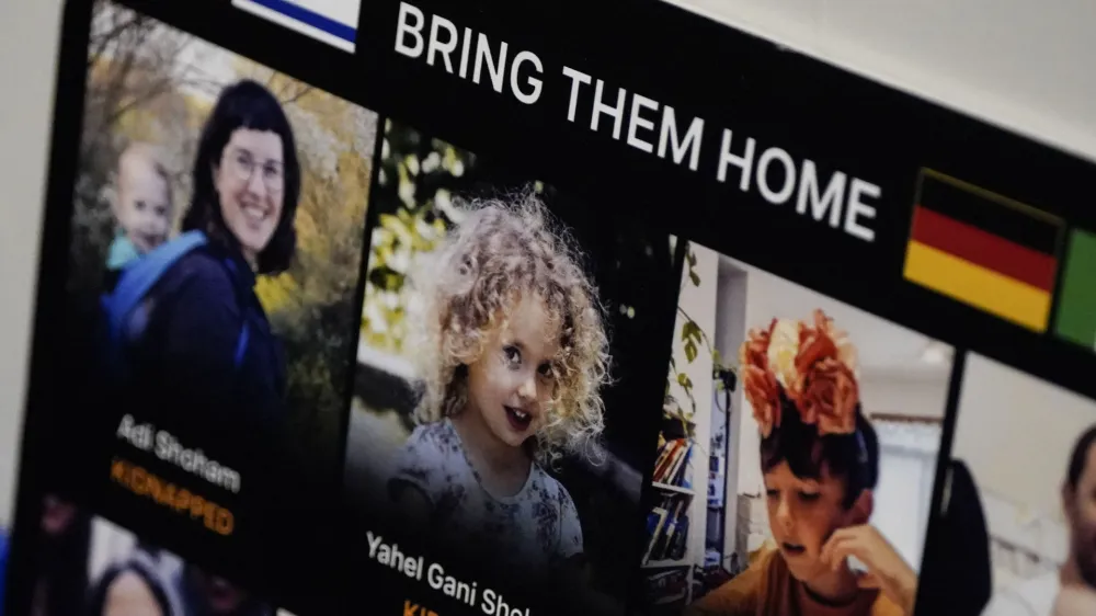 A poster of kidnapped people is seen as family members of people kidnapped by Hamas speak to reporters, bookended by remarks from Georgia lawmakers supportive of Israel and the Israeli consul general. during a news conference inside the state capitol, Monday, Oct. 30, 2023, in Atlanta. (AP Photo/Mike Stewart)