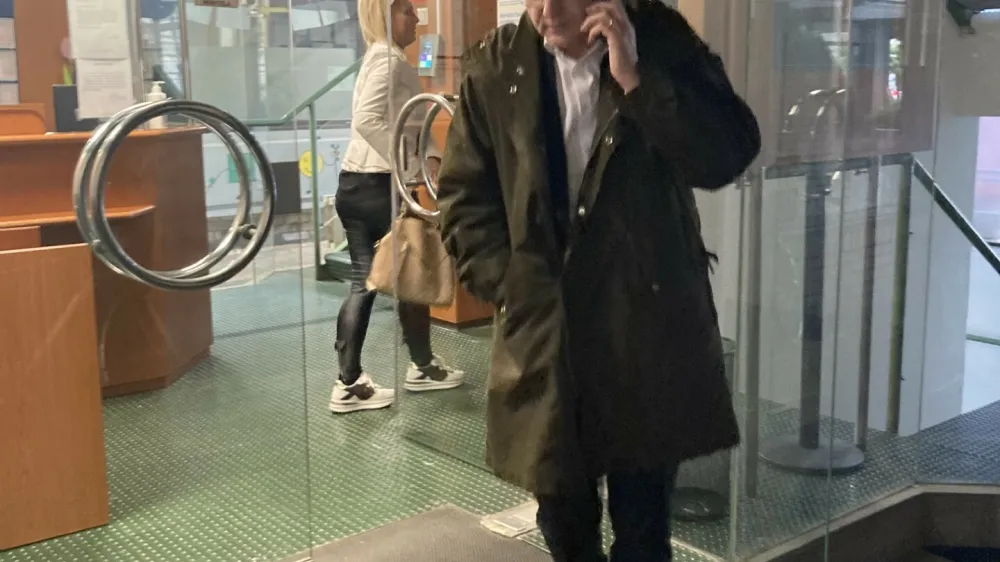 Odvetnik Blaž Žibert, v ozadju Petra Zakraj&scaron;ek, ki se je skrivala pred fotoaparati, menita, da je bila izredna odpoved Zakraj&scaron;ek, ki jo je prejela lani julija, ko je že nastopila vlada, ki jo vodi Robert Golob, politična in nezakonita. <br>--<br>